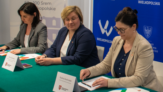 trzy kobiety siedzące za stołem podpisujące umowa na dofinansowanie