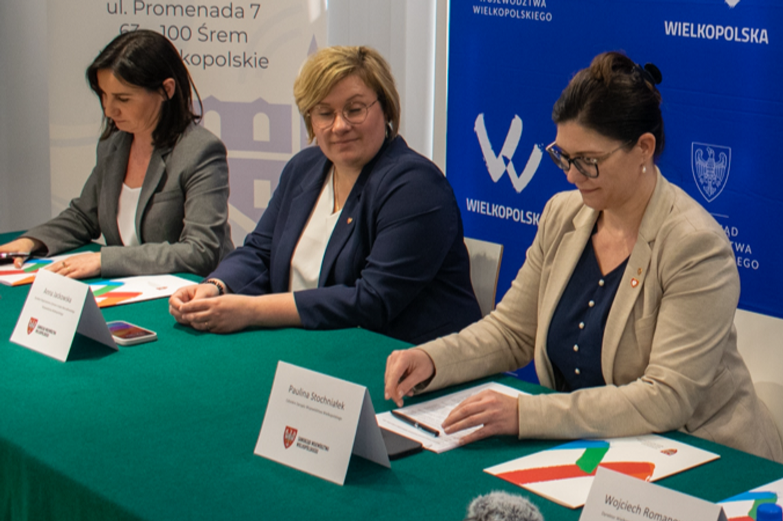 trzy kobiety siedzące za stołem podpisujące umowa na dofinansowanie