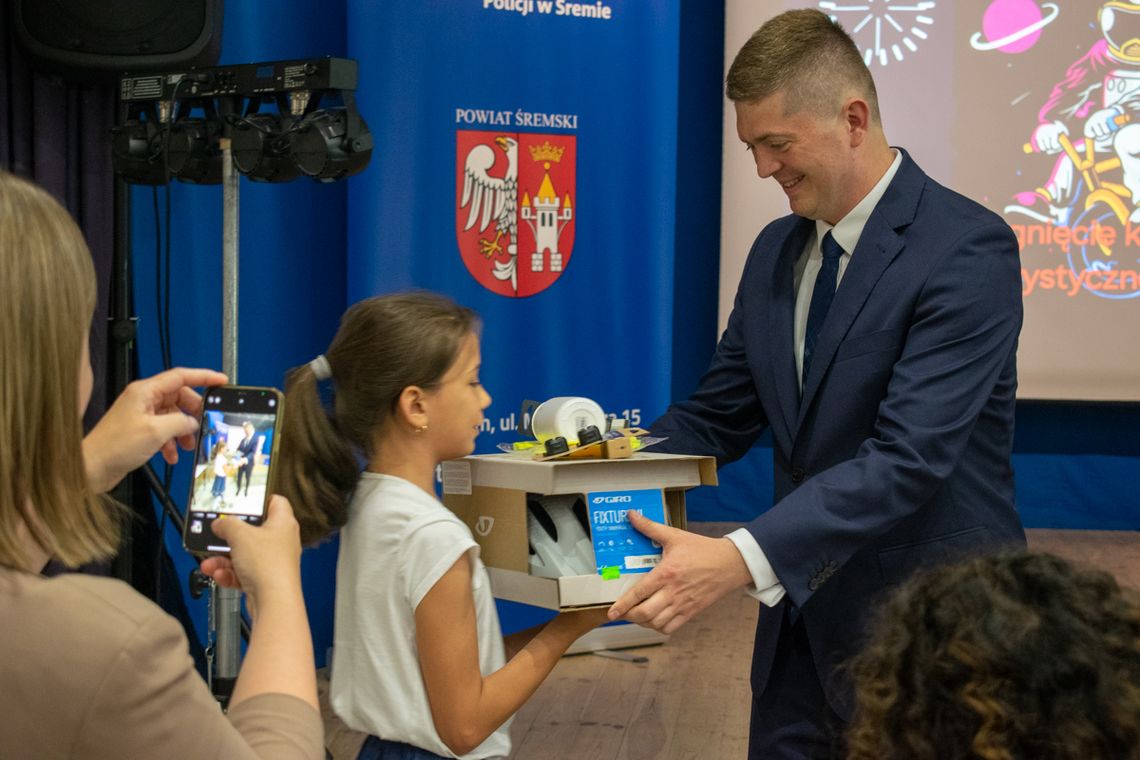 dziewczynka odbiera nagrody z rąk burmistrza Śremu