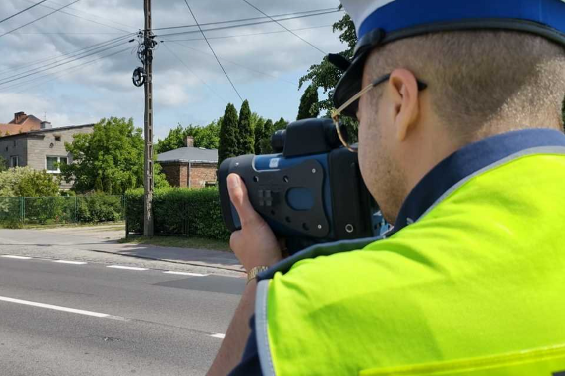 policjant z radarem mierzy prędkość kierujących